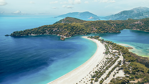 Blick auf die malerische Küstenstadt Fethiye in der Provinz Muğla mit türkisblauem Meer und grünen Bergen.